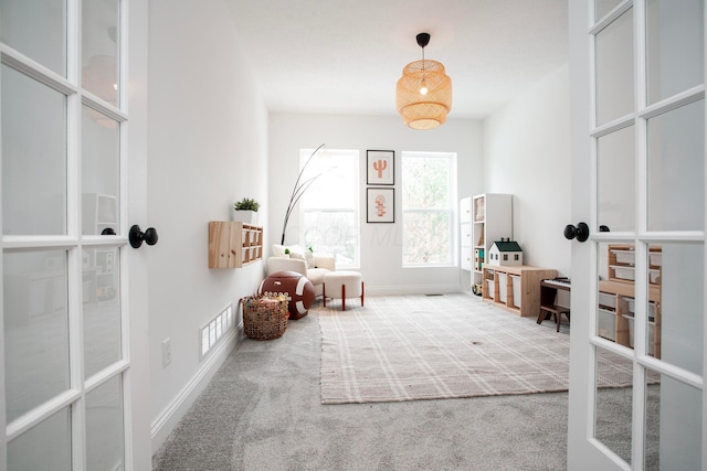 interior space with carpet and french doors