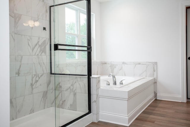 bathroom featuring hardwood / wood-style flooring and plus walk in shower