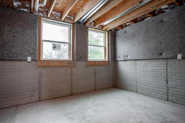 empty room with concrete floors and brick wall