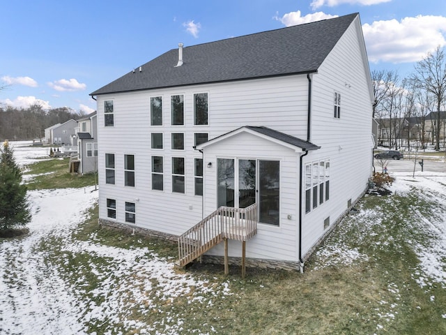 view of snow covered rear of property