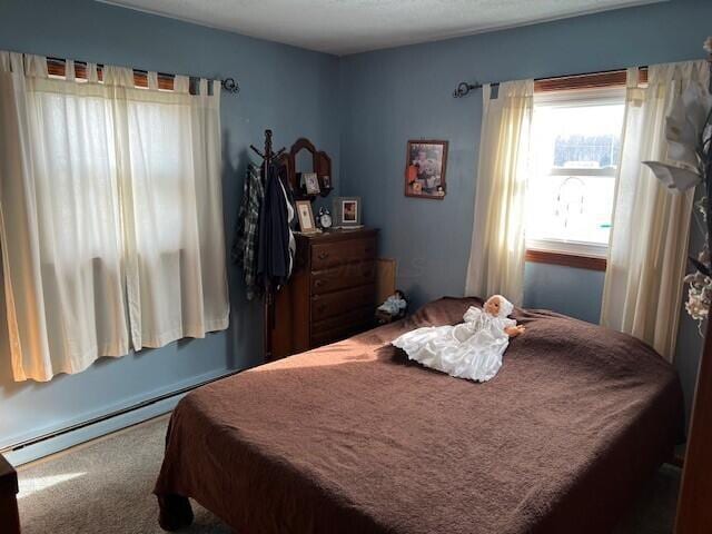 bedroom featuring baseboard heating and carpet