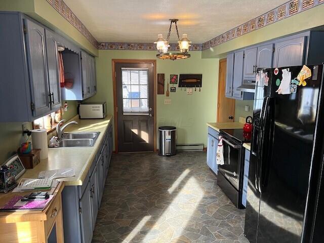 kitchen featuring sink, hanging light fixtures, a baseboard heating unit, a notable chandelier, and black appliances