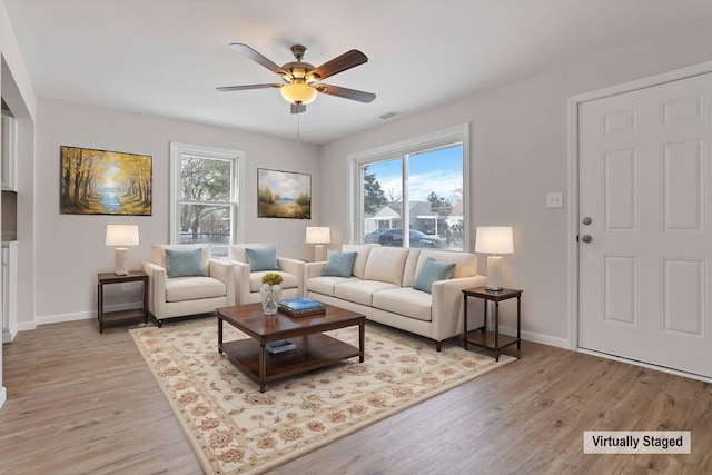 living room with ceiling fan and light hardwood / wood-style flooring