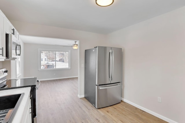 kitchen with ceiling fan, appliances with stainless steel finishes, light hardwood / wood-style floors, and white cabinets