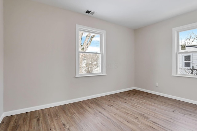 spare room with light hardwood / wood-style flooring and a wealth of natural light