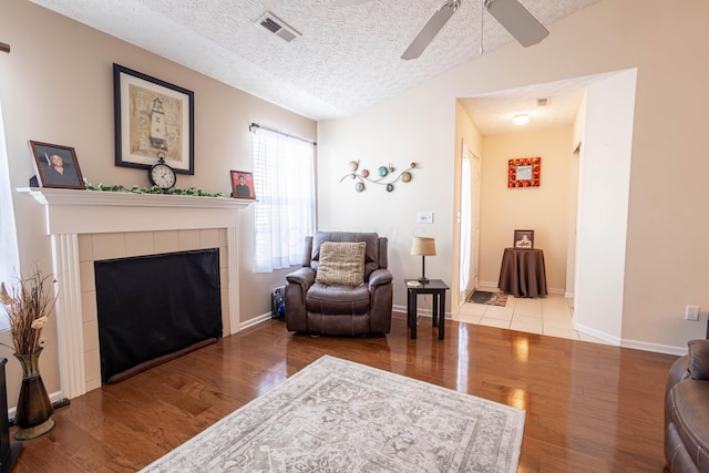 sitting room with vaulted ceiling, a textured ceiling, and light hardwood / wood-style floors