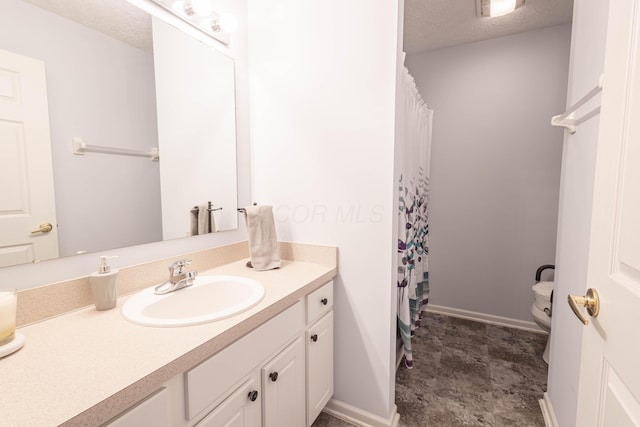 bathroom featuring vanity, toilet, and a textured ceiling