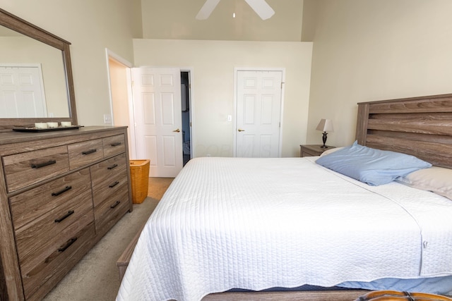 carpeted bedroom with ceiling fan and a towering ceiling