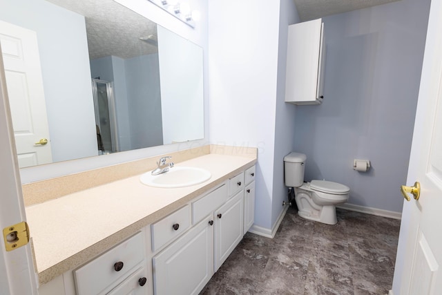 bathroom with a shower with door, vanity, a textured ceiling, and toilet