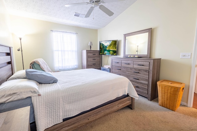 bedroom with ceiling fan, lofted ceiling, light carpet, and a textured ceiling