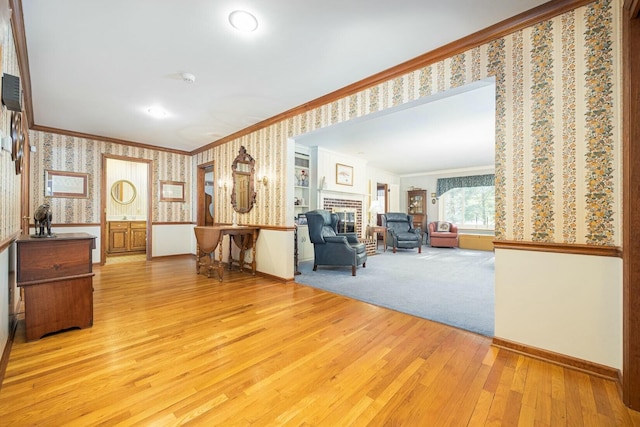 unfurnished room featuring ornamental molding, a brick fireplace, and light wood-type flooring