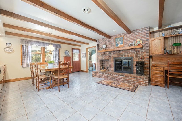 tiled dining room featuring a fireplace and beam ceiling