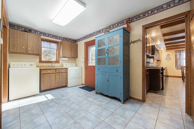 kitchen with light tile patterned flooring, washer / clothes dryer, and sink