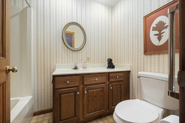 bathroom featuring vanity, toilet, and a tub