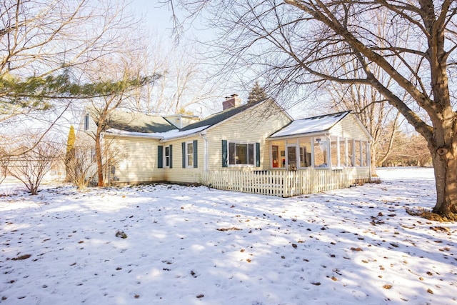 snow covered house with a sunroom