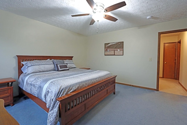 bedroom with ceiling fan, light colored carpet, and a textured ceiling