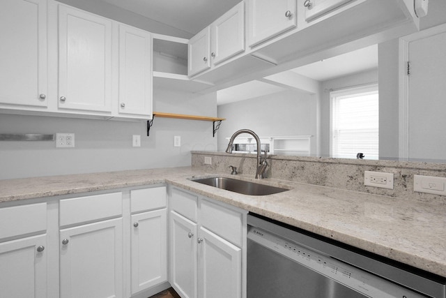 kitchen featuring dishwasher, light stone countertops, sink, and white cabinets