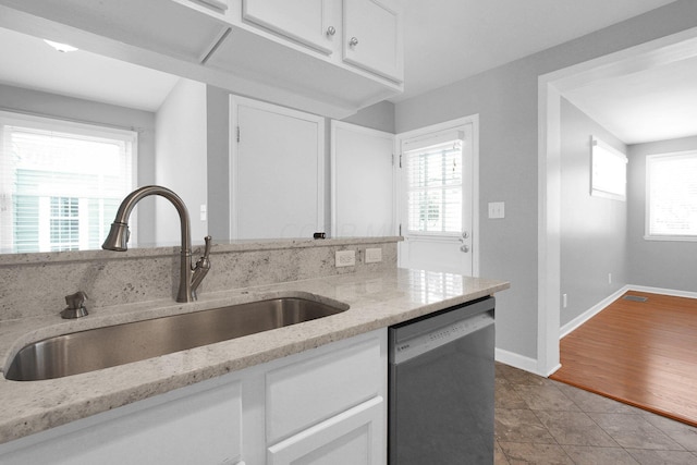 kitchen with a wealth of natural light, dishwasher, sink, and white cabinets