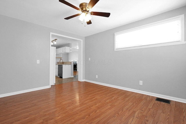 unfurnished living room with sink, hardwood / wood-style flooring, and ceiling fan