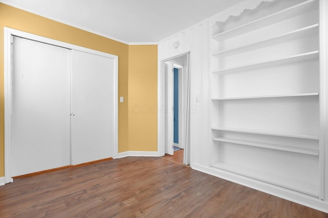 unfurnished bedroom with ornamental molding, dark hardwood / wood-style floors, and a closet