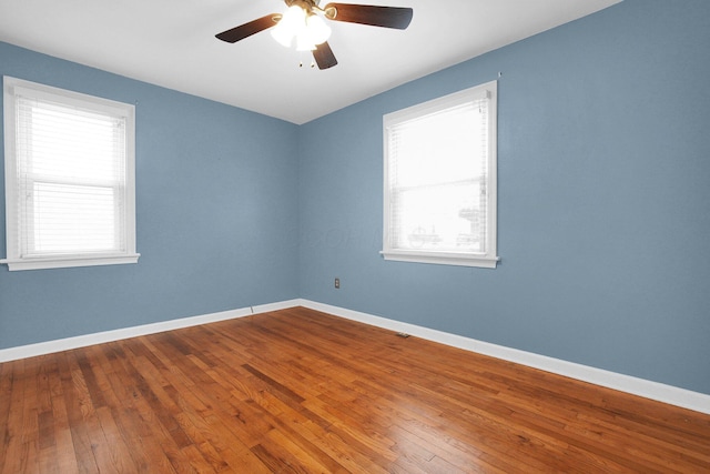 empty room with wood-type flooring, a wealth of natural light, and ceiling fan