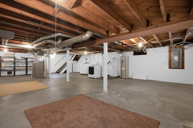 basement featuring water heater, washing machine and clothes dryer, heating unit, and electric panel