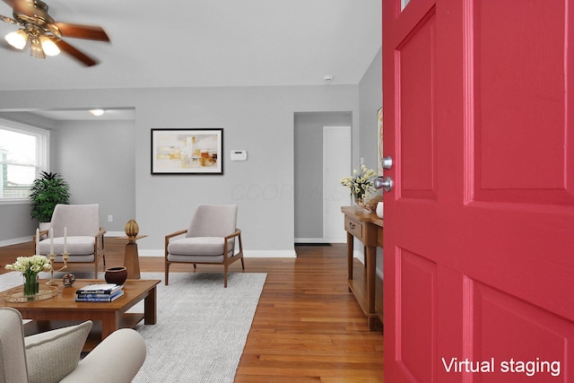 living room featuring wood-type flooring and ceiling fan