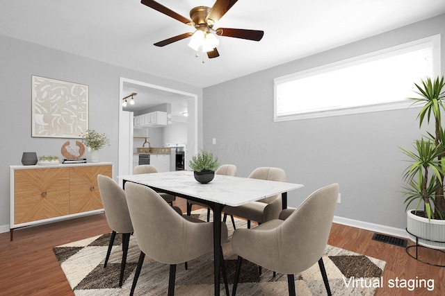 dining area featuring ceiling fan and dark hardwood / wood-style flooring