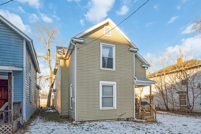 view of snow covered rear of property