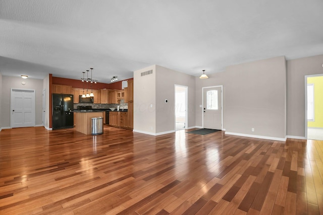 unfurnished living room featuring dark wood-type flooring and track lighting