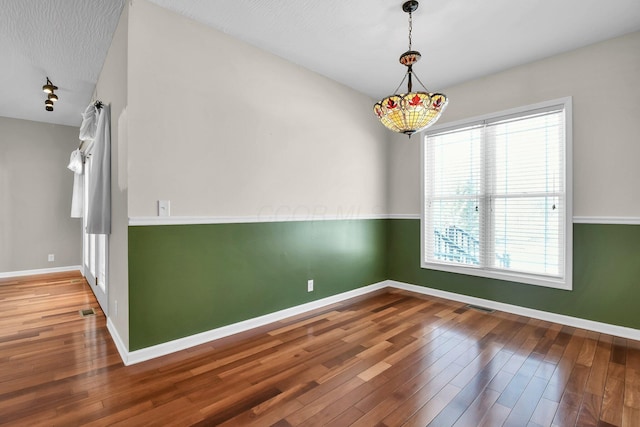 spare room with wood-type flooring and a textured ceiling