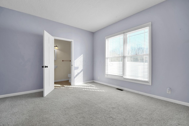 carpeted empty room with a textured ceiling