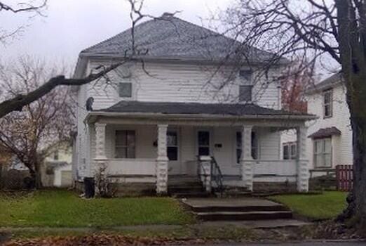 view of front of house with a porch and a front lawn