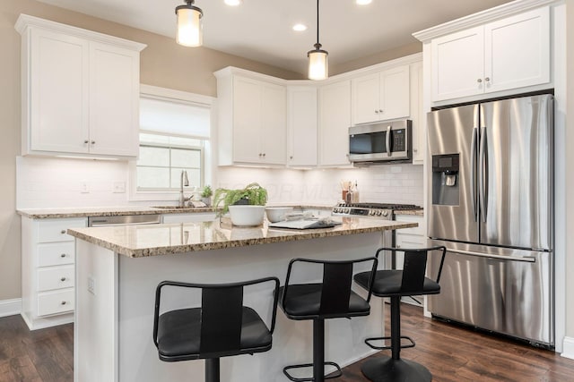 kitchen with hanging light fixtures, white cabinets, and appliances with stainless steel finishes