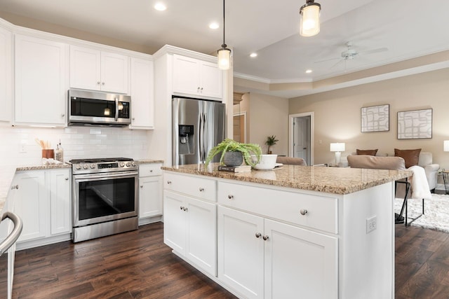 kitchen featuring dark hardwood / wood-style floors, pendant lighting, white cabinets, a center island, and stainless steel appliances