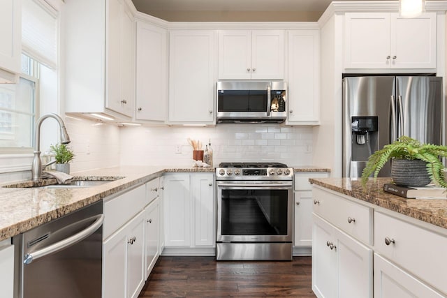 kitchen featuring white cabinetry, sink, light stone counters, and appliances with stainless steel finishes