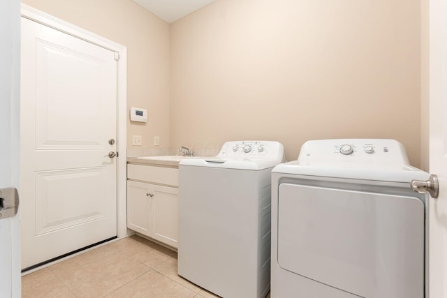 washroom featuring cabinets, washer and clothes dryer, sink, and light tile patterned floors