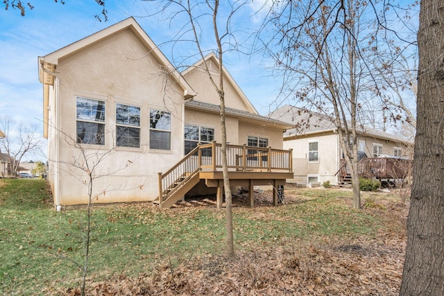 back of property featuring a wooden deck and a yard