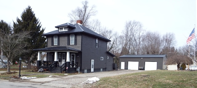 view of front of home featuring a garage, an outdoor structure, a front lawn, and a porch