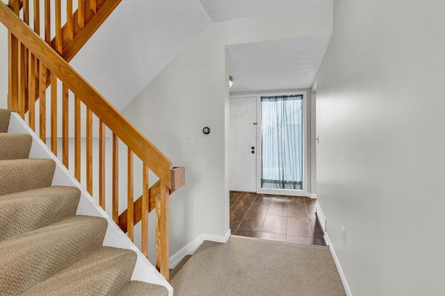 carpeted foyer featuring a textured ceiling