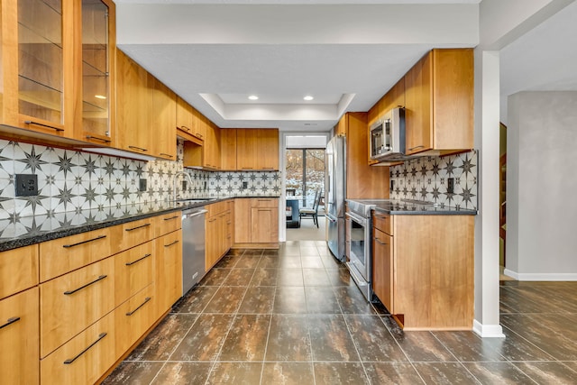 kitchen featuring stainless steel appliances, sink, backsplash, and a tray ceiling