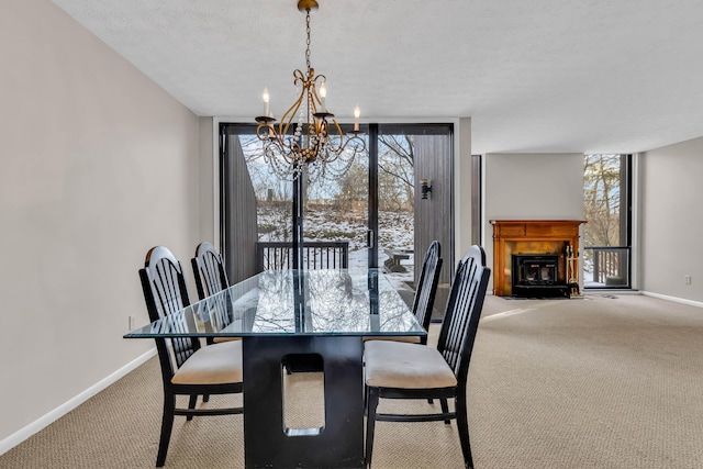 dining space with a wealth of natural light, expansive windows, a textured ceiling, and carpet flooring