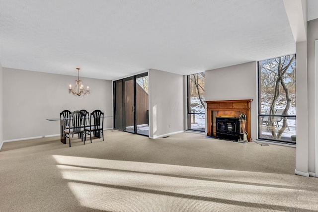 carpeted living room with plenty of natural light, expansive windows, and a chandelier