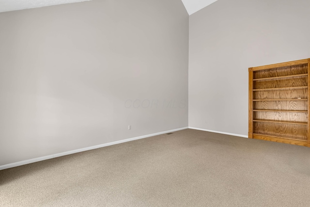 carpeted spare room featuring lofted ceiling