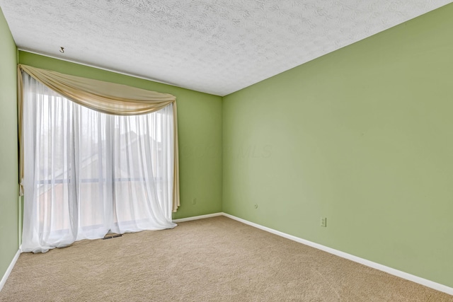 carpeted empty room featuring a textured ceiling