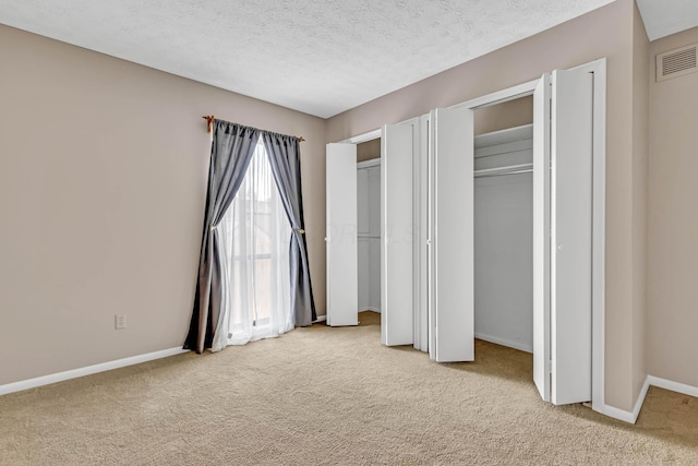 unfurnished bedroom with carpet and a textured ceiling