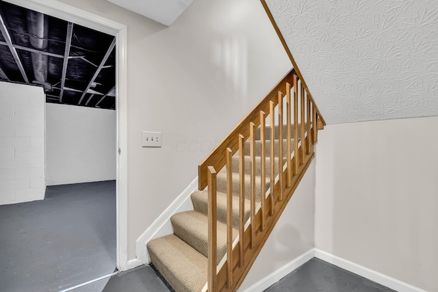 stairs featuring concrete flooring