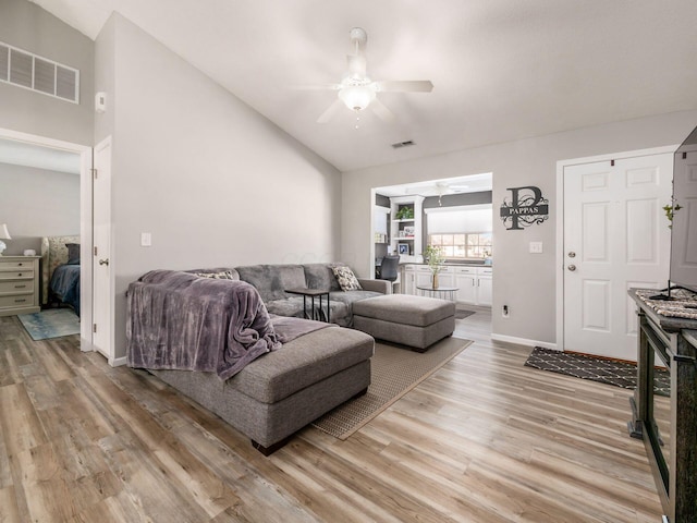 living room with vaulted ceiling, hardwood / wood-style floors, and ceiling fan