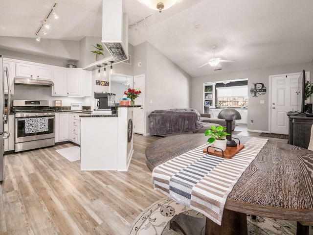 kitchen featuring lofted ceiling, stainless steel gas range, light hardwood / wood-style floors, and white cabinets