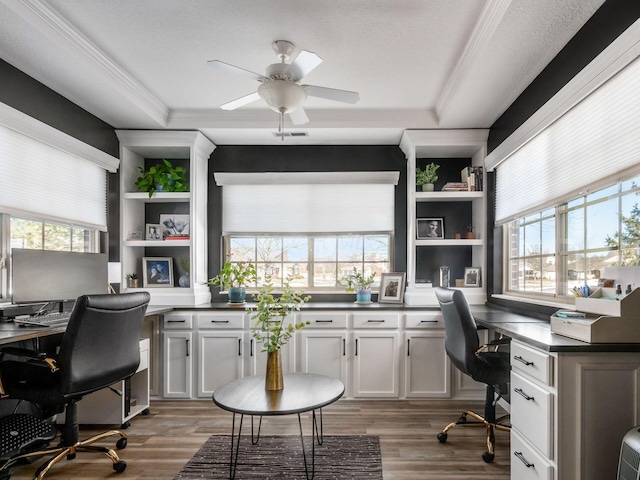 home office featuring a wealth of natural light, dark hardwood / wood-style floors, built in desk, and a textured ceiling